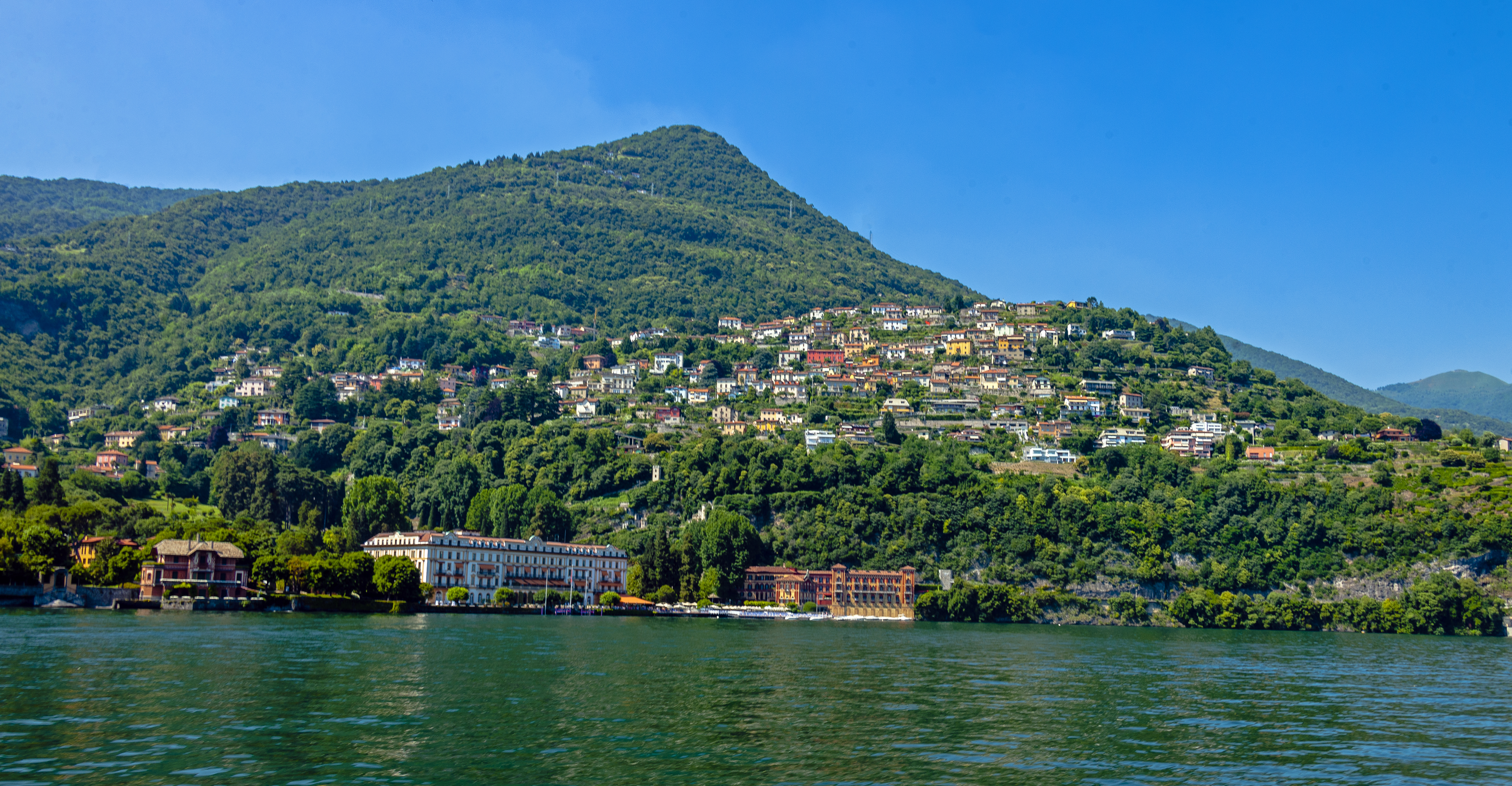 Una foto della tipica "Riva" di Cernobbio con le barche in legno ormeggiate e i monti sullo sfondo