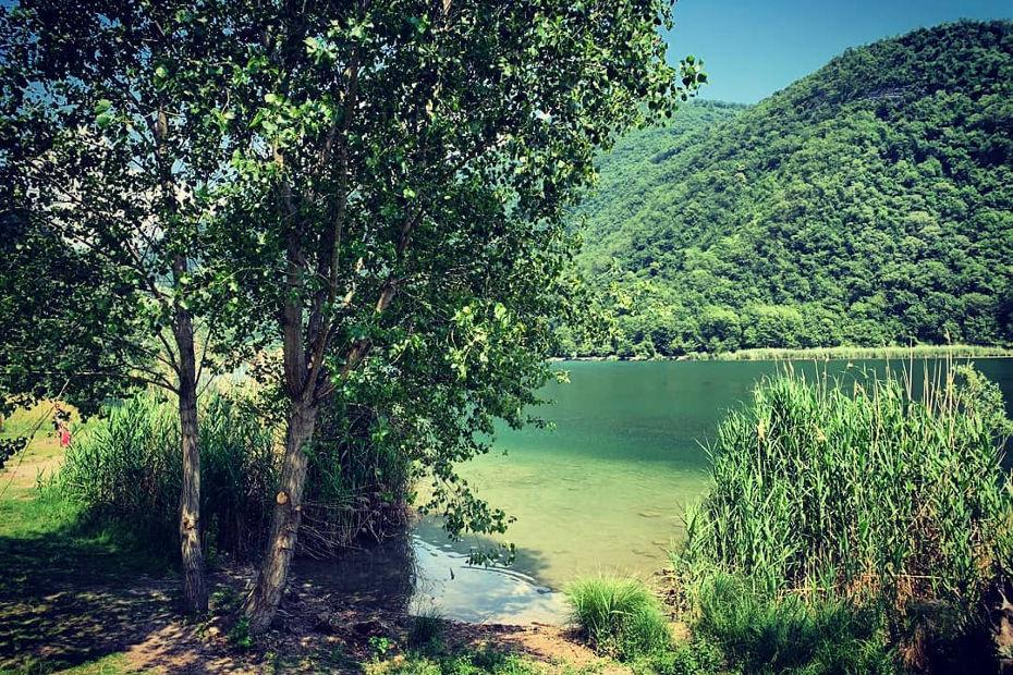 Le acque verde smeraldo del Lago del Segrino costeggiate dalla pista ciclo-pedonale