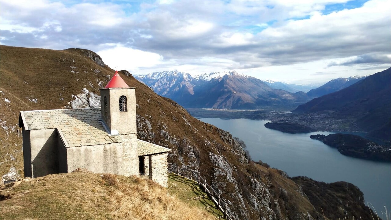 Il profilo della trecentesca Chiesa di San Biagio a ridosso dell'acqua o lo sperone del Sasso di Musso