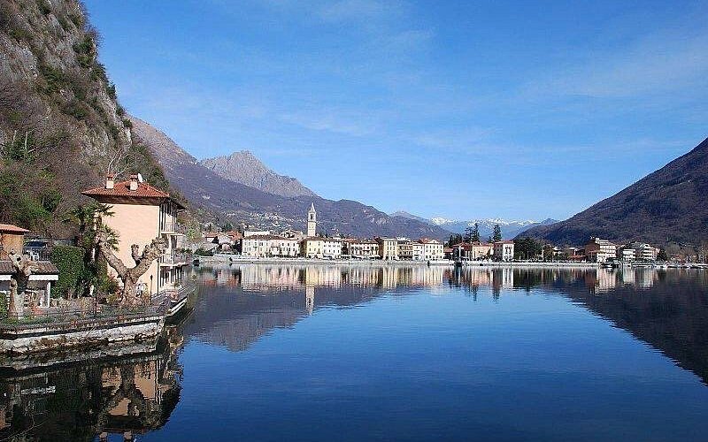 Il lungolago di Porlezza con le montagne che si riflettono nell'acqua