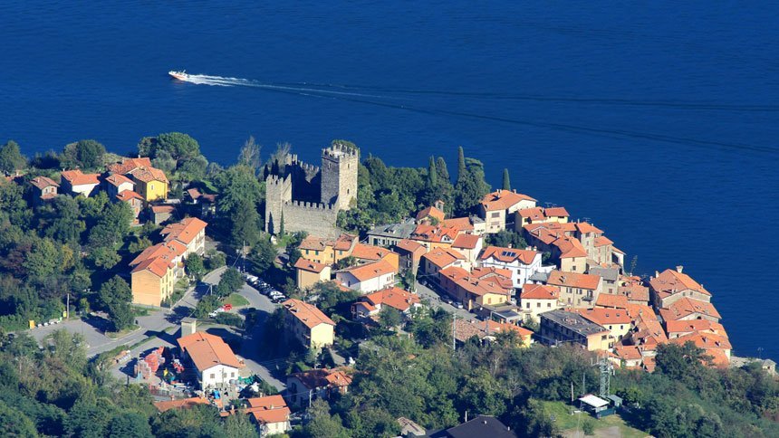 Un sentiero che attraversa un borgo in pietra verso il lago