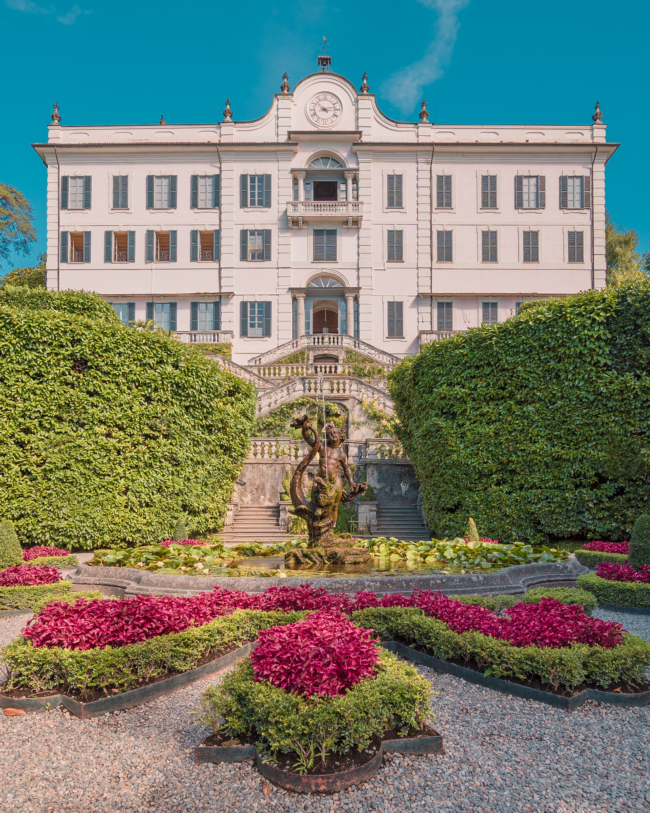Uno scatto panoramico che mostri Villa Carlotta o Villa del Balbianello con l'acqua scintillante del lago